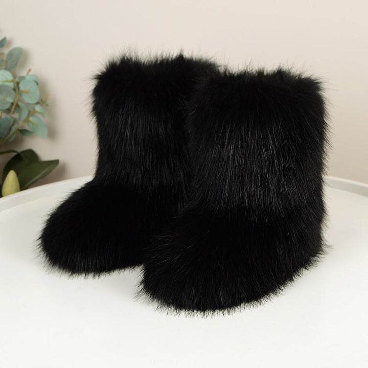 Black shaggy faux fur boots on a white floor