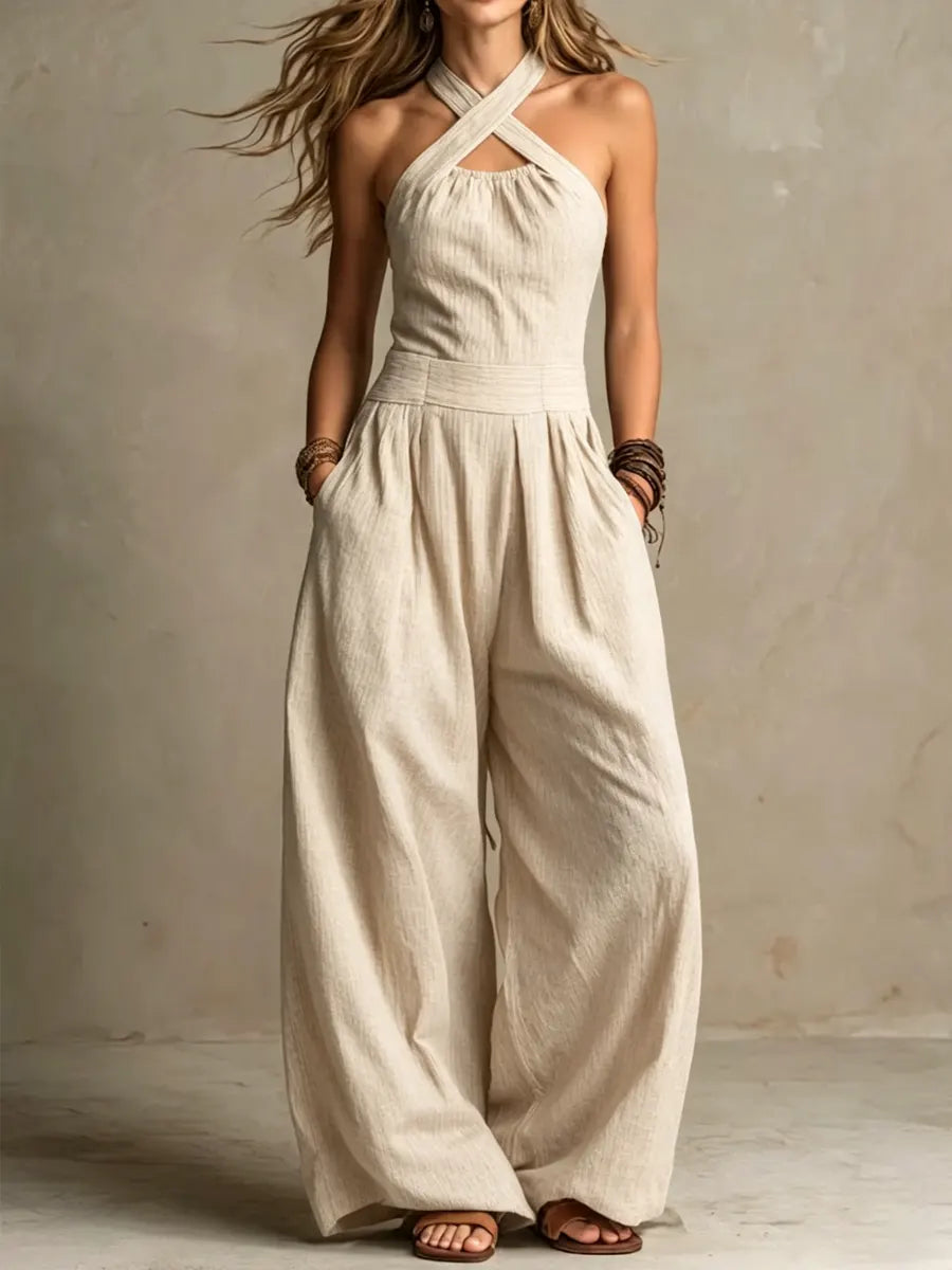 Beige wide leg halter jumpsuit with a crossover neck, full-length front view