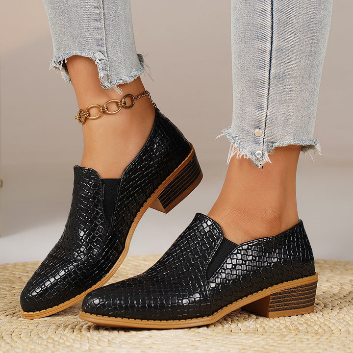 Pair of black woven look loafers with a chain anklet, side view