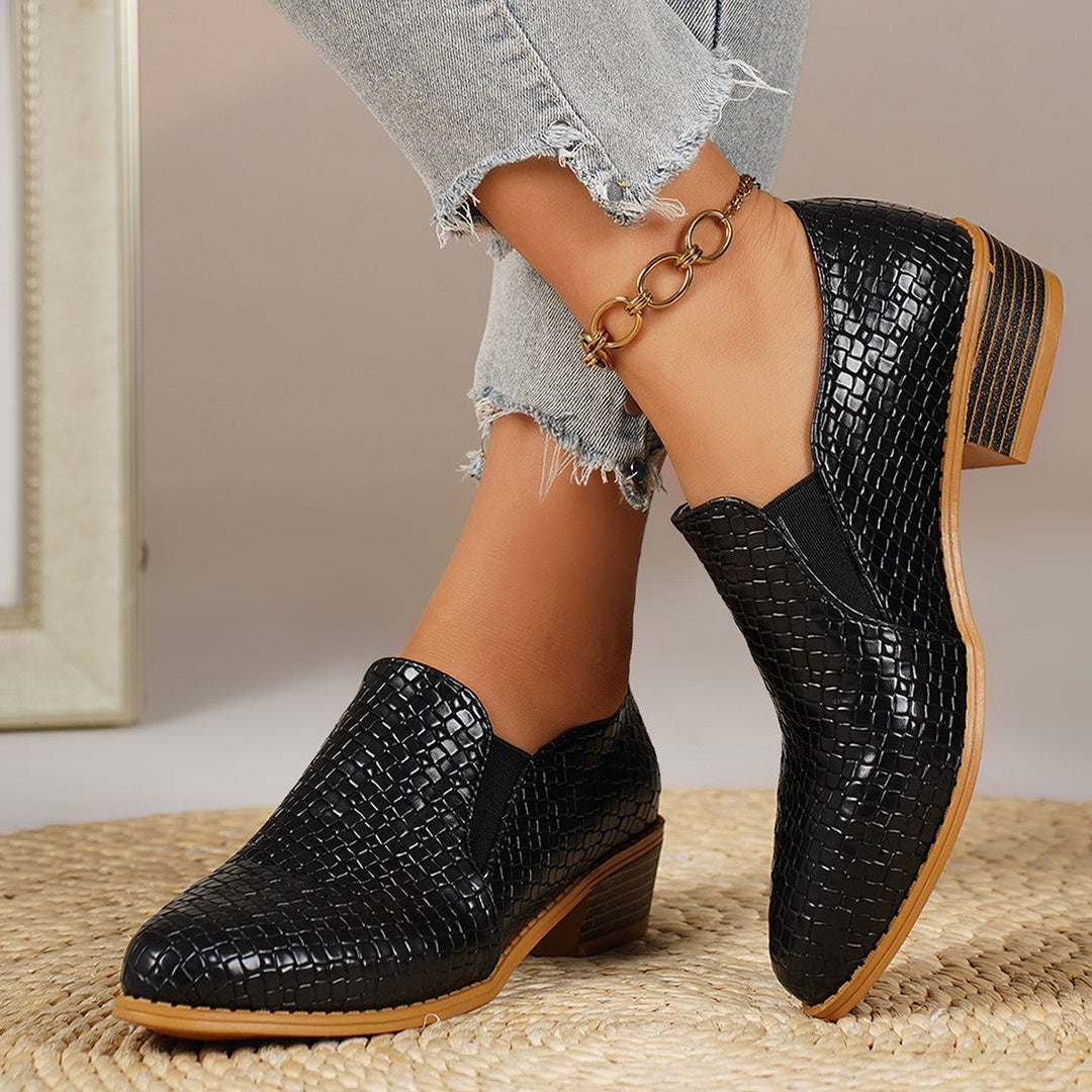 Black heeled loafers with elastic side panel, worn with frayed hem jeans