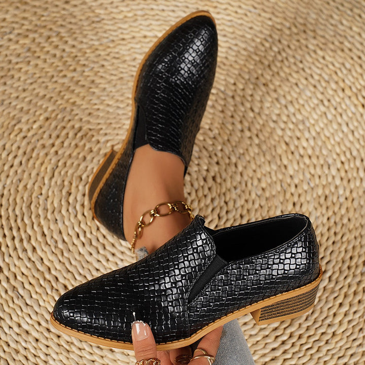 Black woven look slip on loafers with pointed toe, shown with an ankle chain