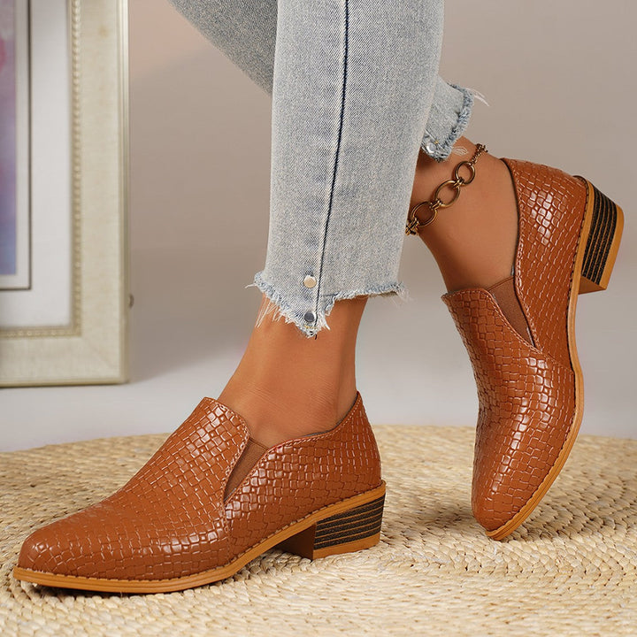 Cognac woven look loafers on feet, front angled view with jeans