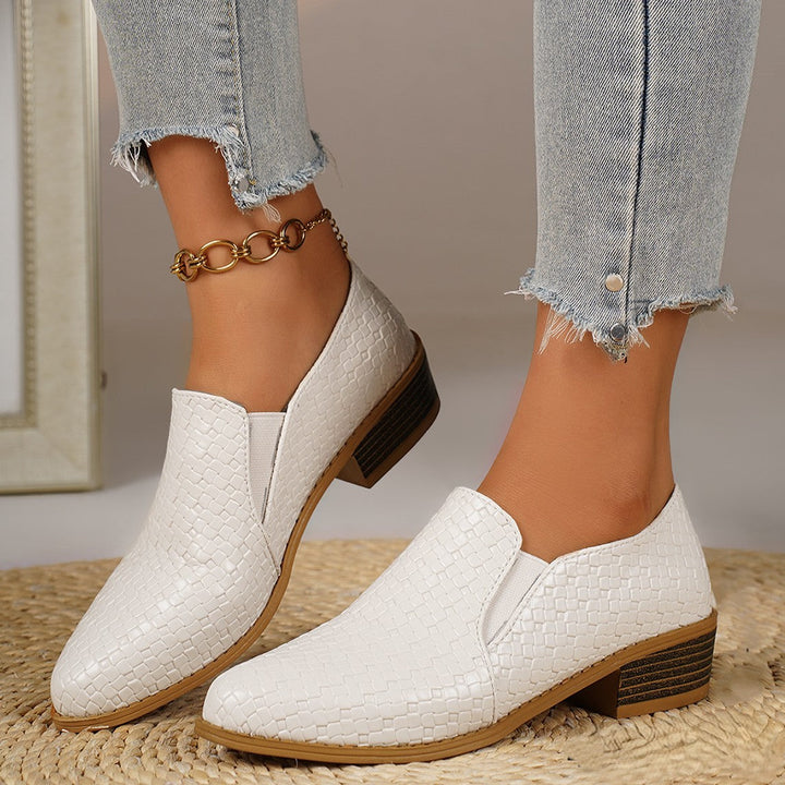 White pointed toe heeled loafers worn with cropped frayed jeans