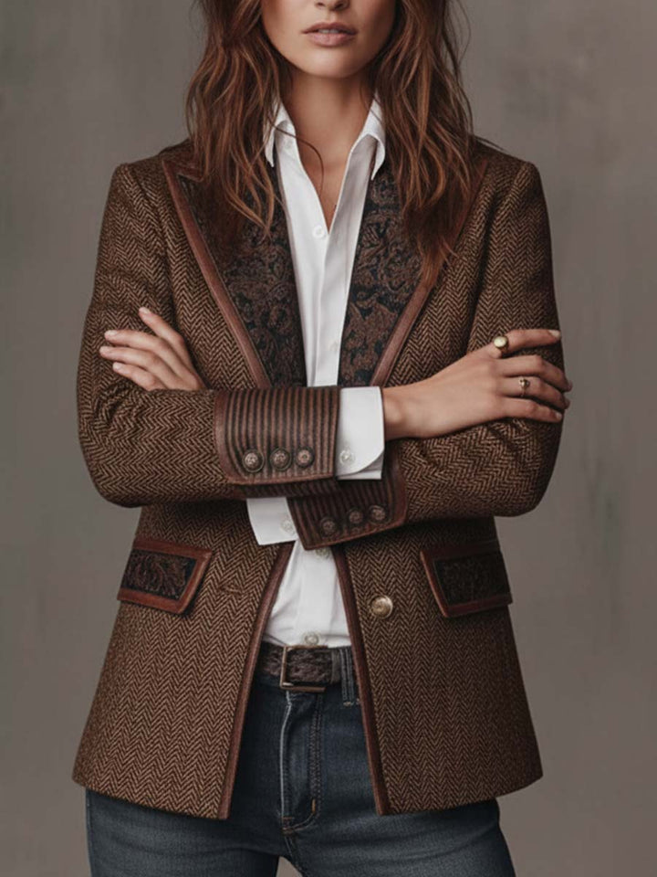 Brown herringbone blazer styled with arms crossed over a white shirt and belt