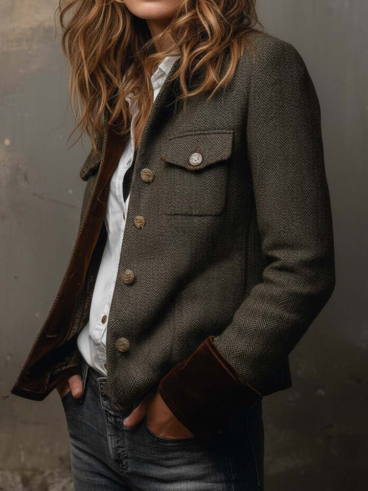Olive herringbone blazer with contrast cuffs, angled view with hands in pockets