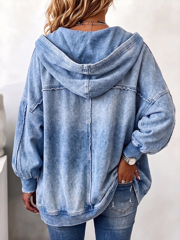 Back of the blue hooded jacket showing the hood and raw-edge seam lines