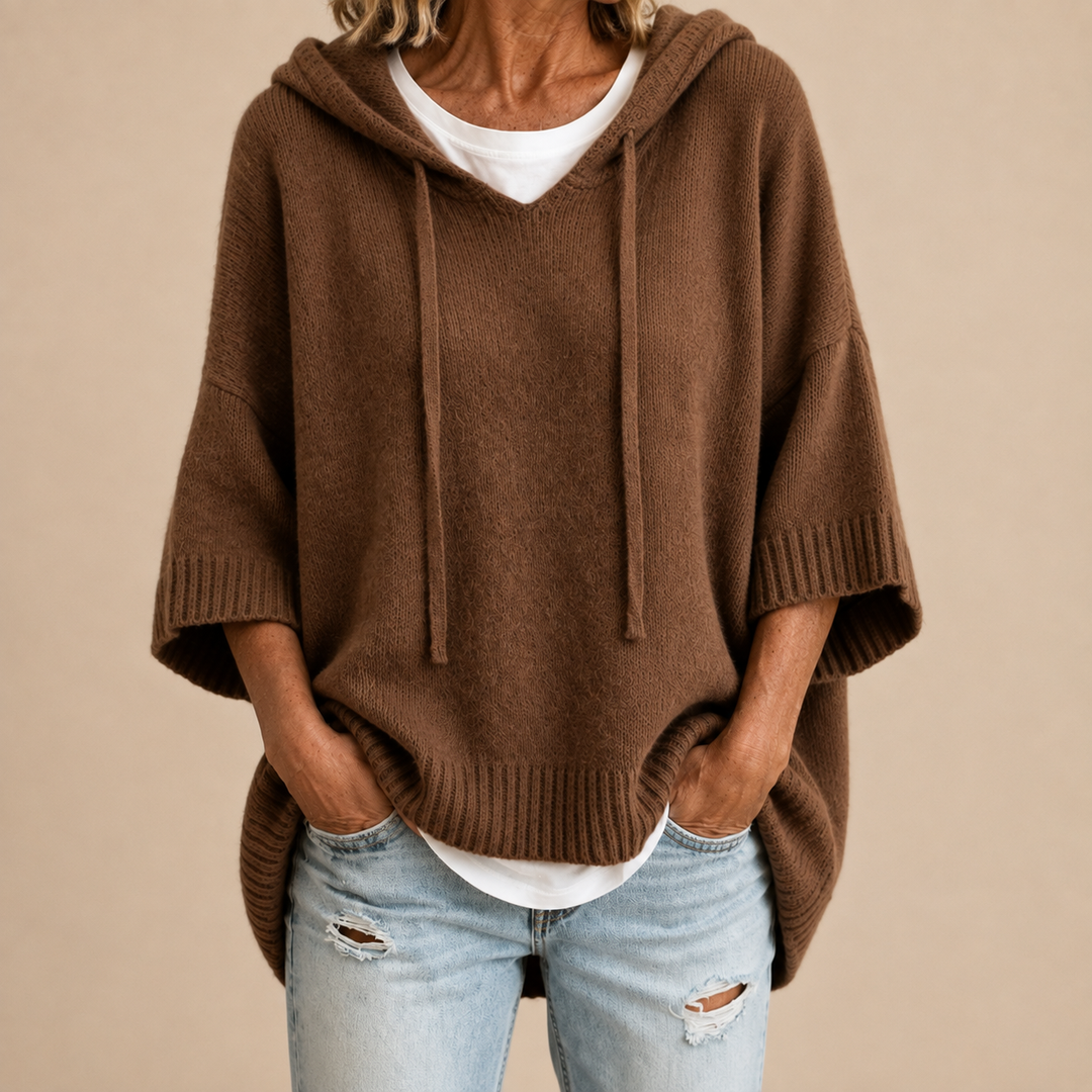 Chocolate brown hooded poncho sweater with ribbed cuffs, worn with light jeans