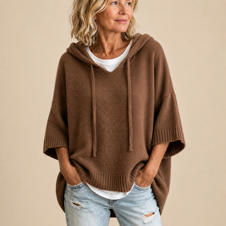 Chocolate hooded poncho sweater with white tee layered underneath, relaxed pose