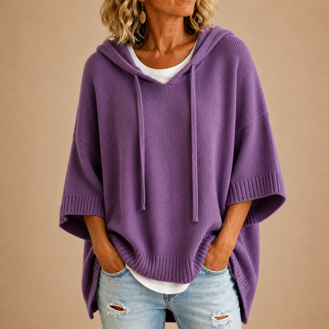 Purple hooded poncho sweater with ribbed hem, worn with light wash jeans