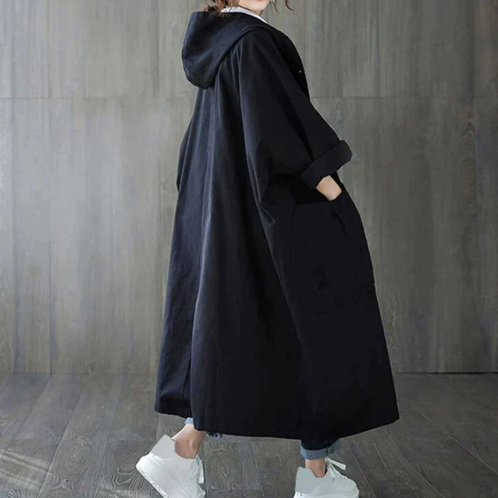 Side view of the black oversized maxi coat with hood and patch pocket
