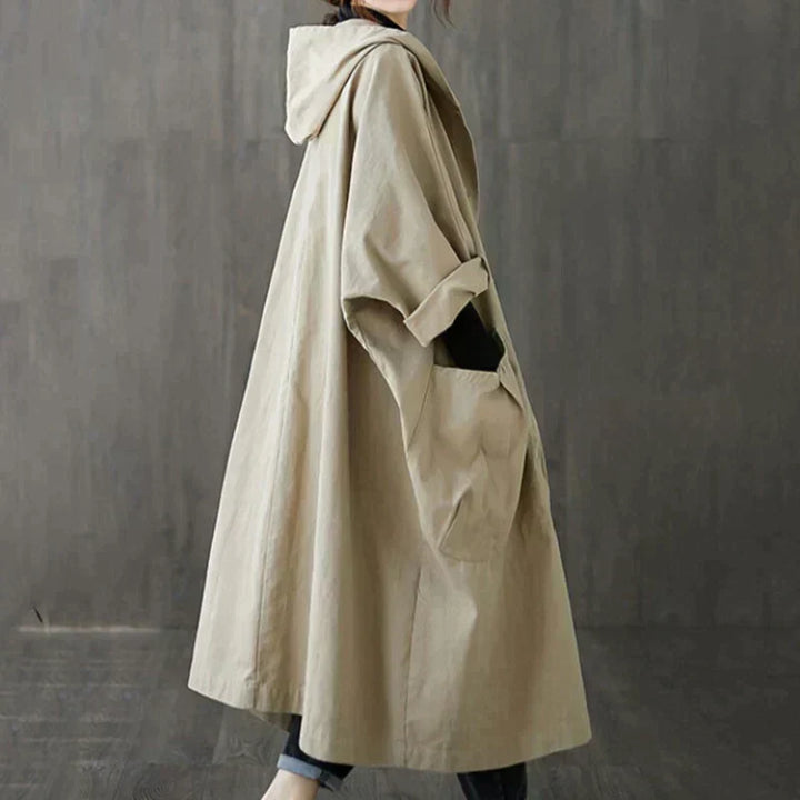Side view of the khaki oversized hooded coat showing the loose drape and hood