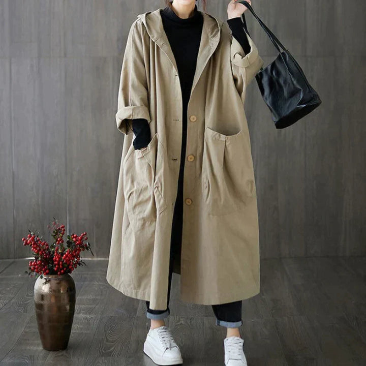 Khaki hooded maxi coat worn open over black top with a black tote bag
