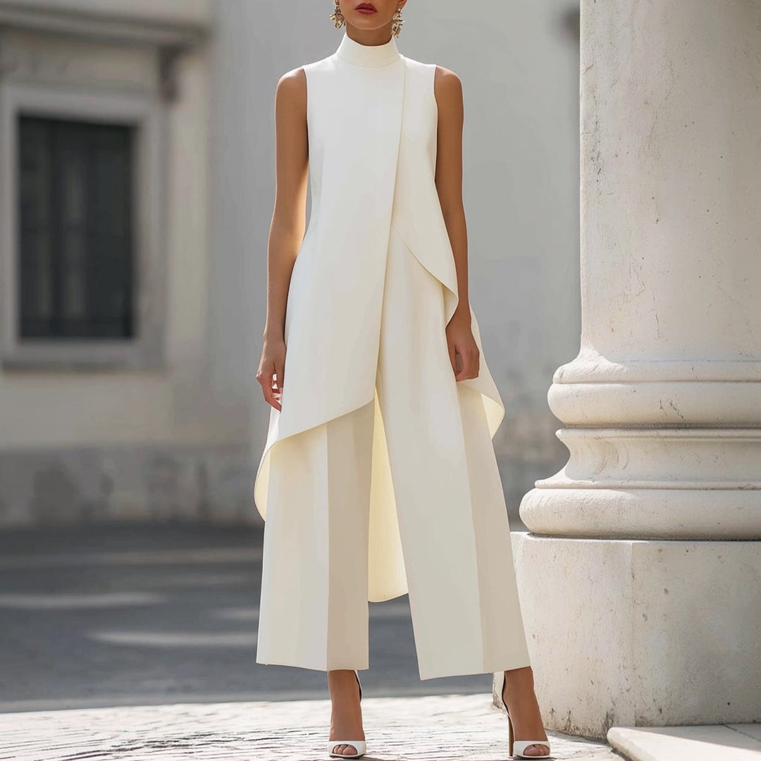 Ivory sleeveless jumpsuit with draped overlay, worn outside beside stone columns
