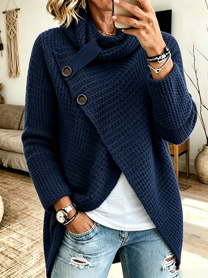 Navy chunky knit sweater with a long curved hem over distressed denim