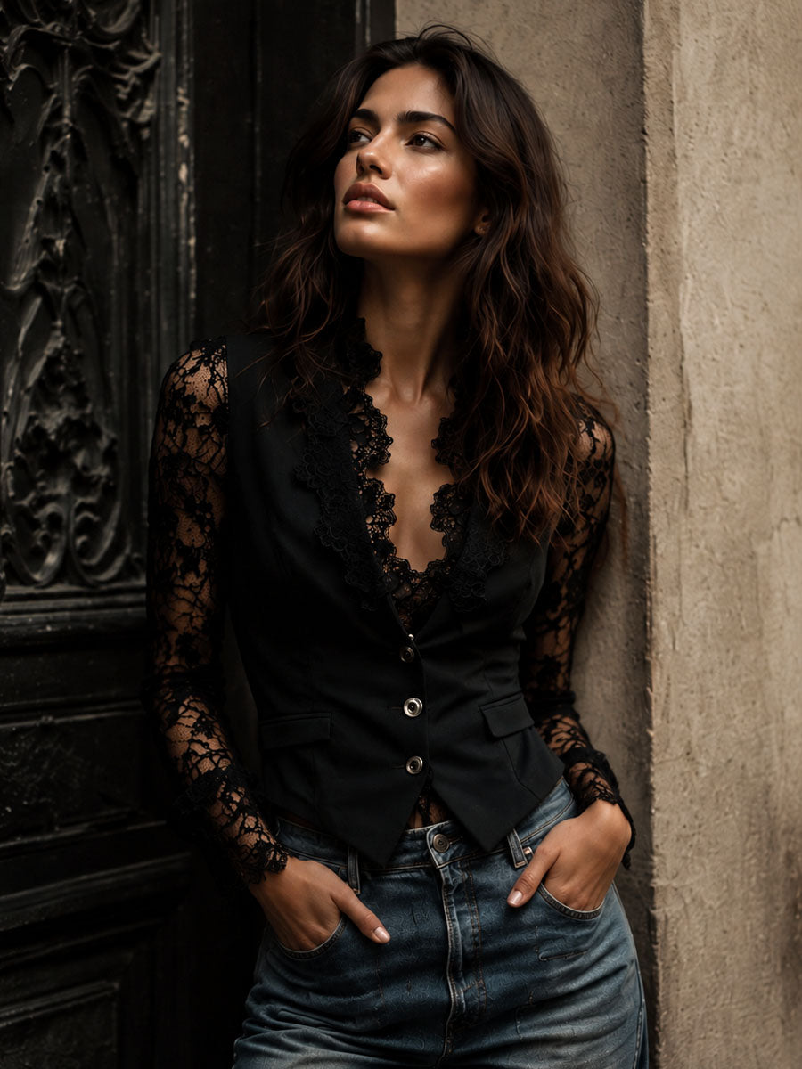 Black fitted lace blazer with lace sleeves styled with jeans against a stone wall