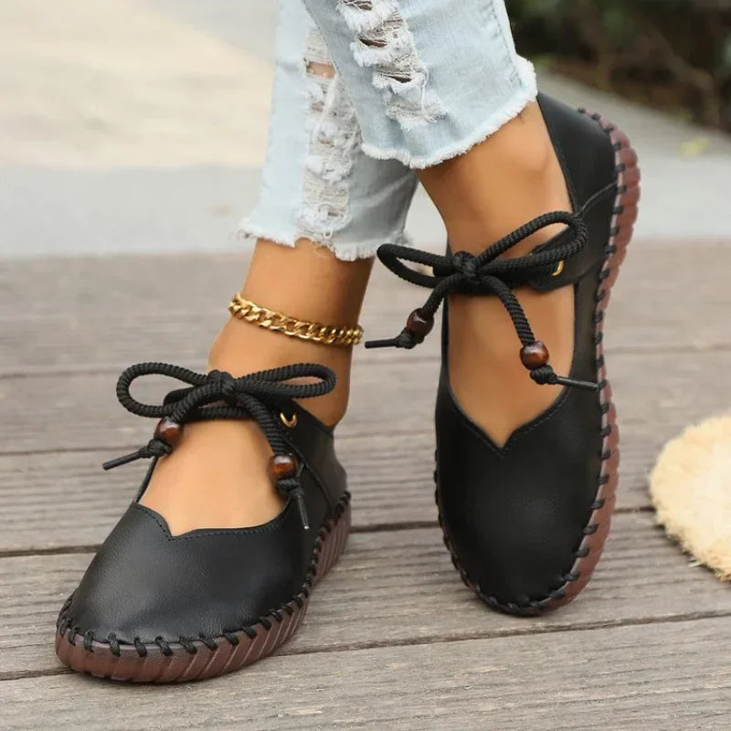 Women's lace up flats in black, stitched round toe with bow tie