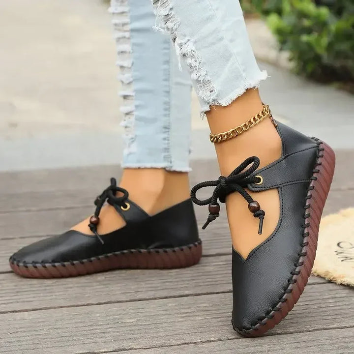Side view of black stitched flats