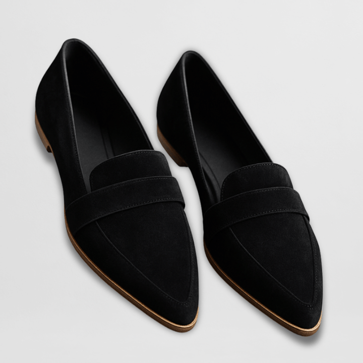 Pair of black suede-look loafers with pointed toes on a light background