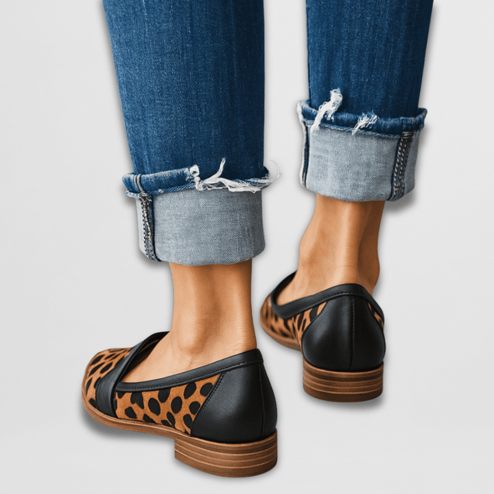Back view of leopard print loafers with black heel and stacked sole, worn with jeans