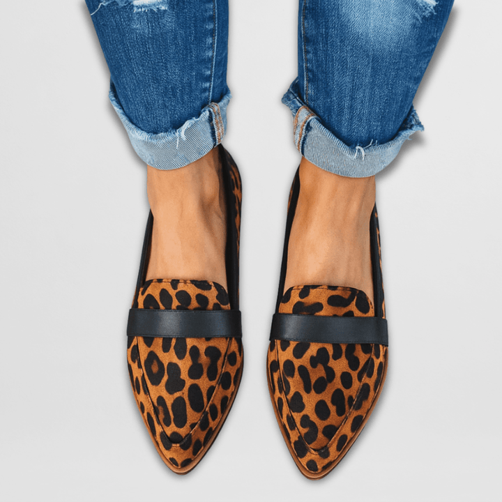 Leopard print slip-on flats with black strap, worn with distressed jeans, front view