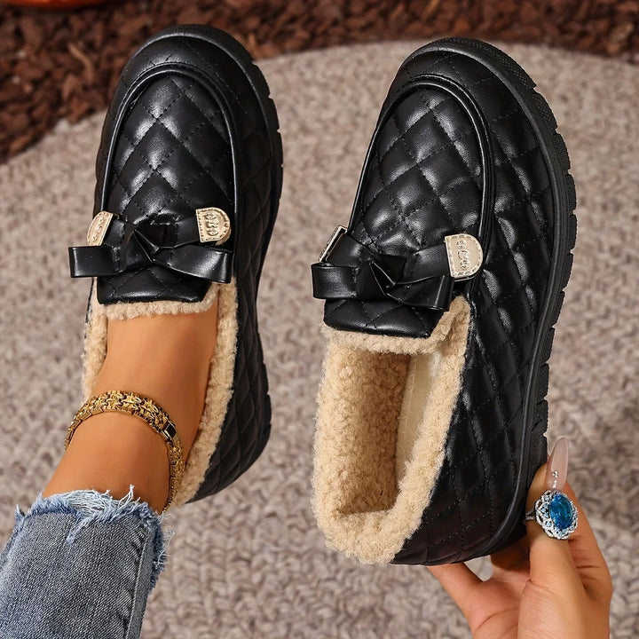 Black quilted loafers with plush lining and bow