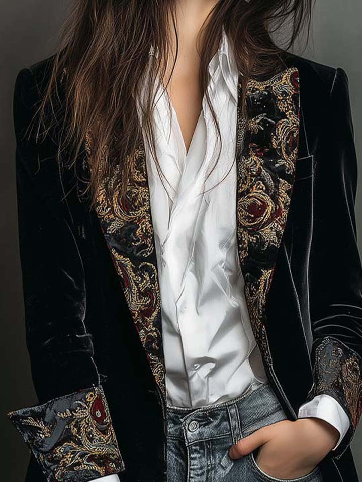 Close-up of the paisley embroidered lapels on the black velvet-look long blazer
