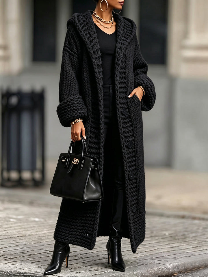 Black chunky knit duster with roomy sleeves on a city street