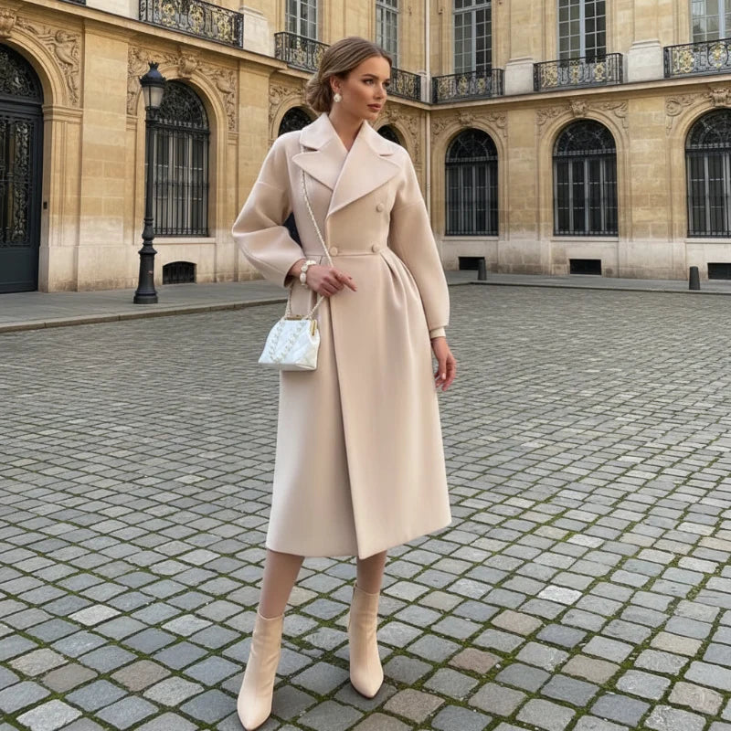 Woman in a beige double breasted long coat standing on a cobblestone square