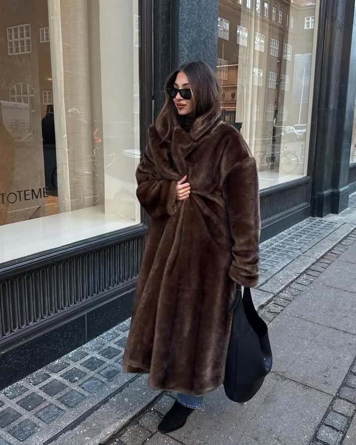 Front view of the dark brown maxi faux fur coat with a high collar on a street
