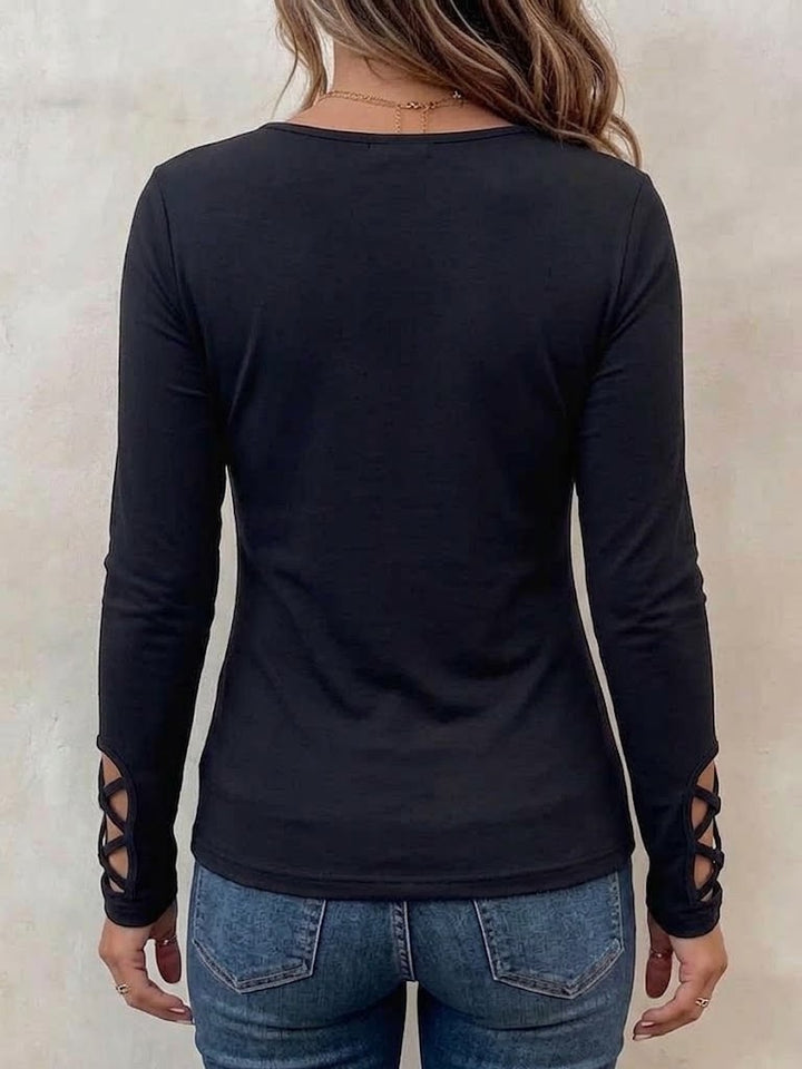 Back view of the fitted black top showing the plain back and strappy cuff detail