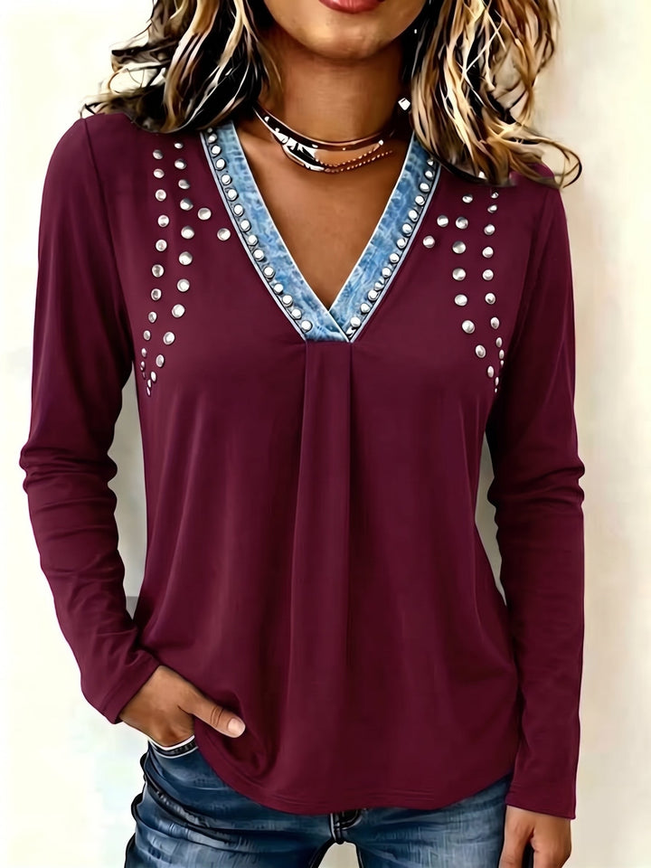 Burgundy studded top with soft gathers below the neckline, worn with dark denim