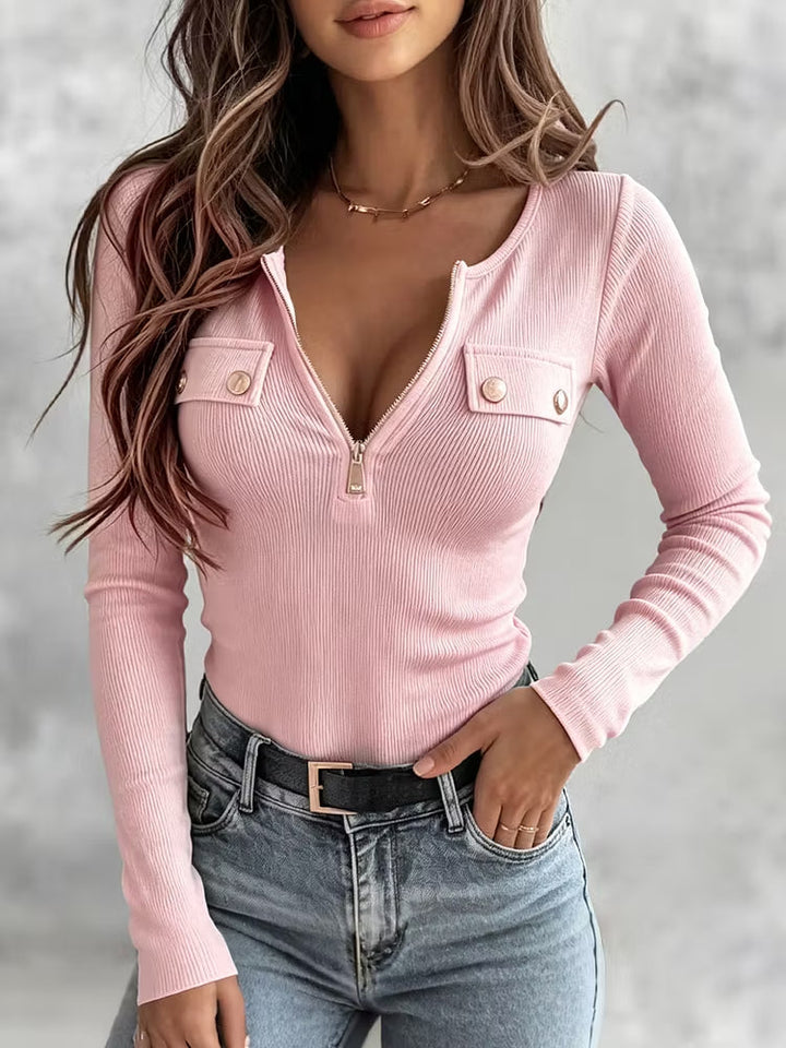 Pale pink half-zip top worn tucked into a black belt
