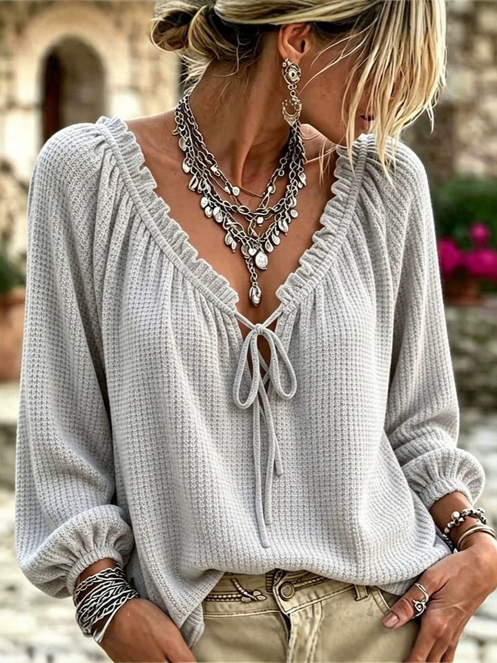 Gray waffle knit top worn with beige pants and silver necklaces