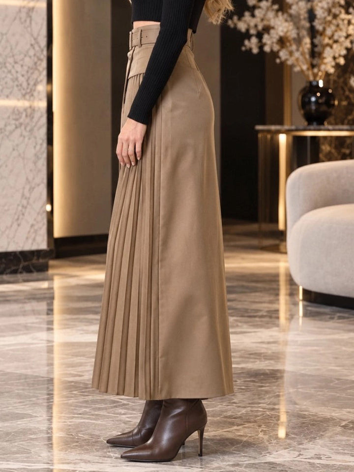 Side view of the camel maxi skirt with pleated panel and heeled boots