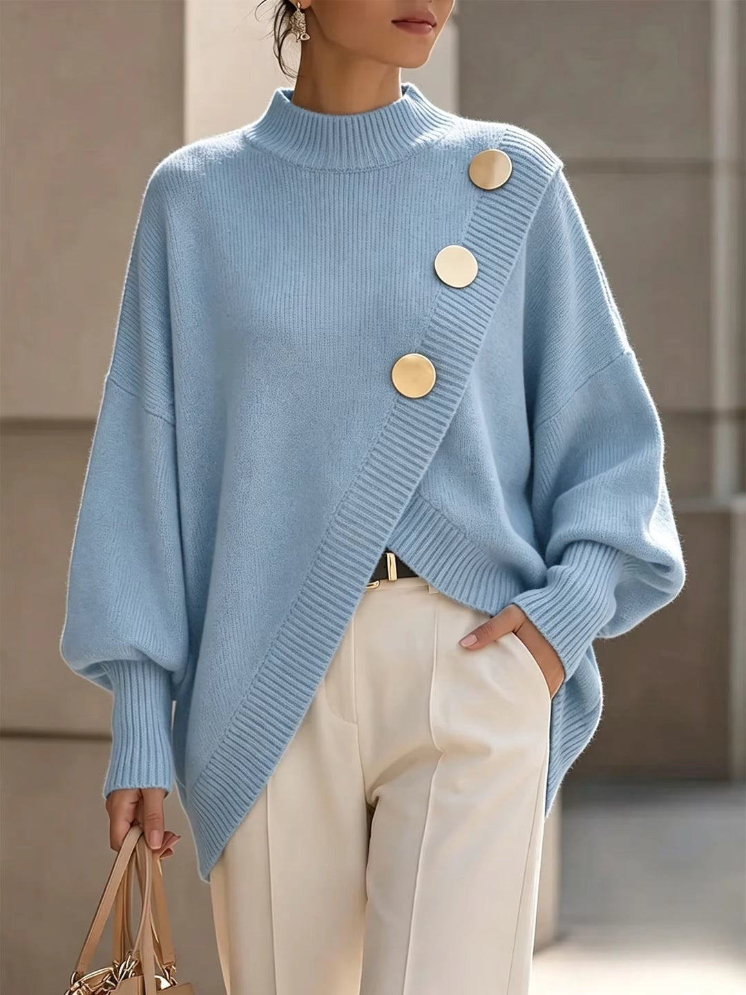Light blue oversized mock neck sweater with asymmetrical gold buttons on a model, front view