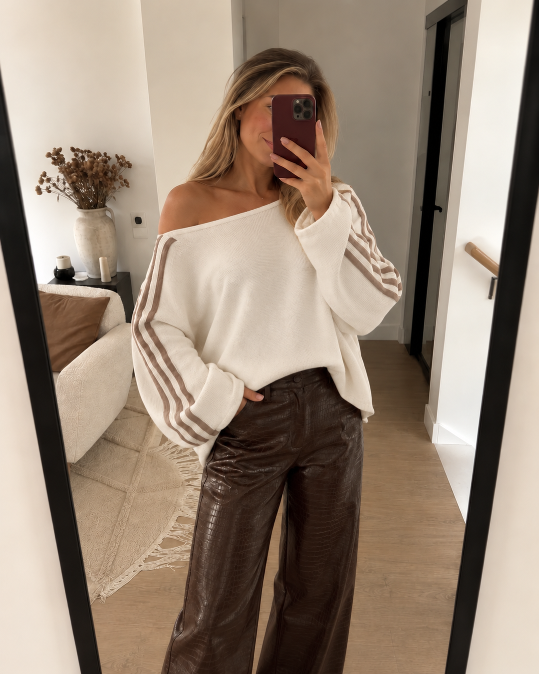 Ivory off shoulder sweater with brown leather pants in a mirror selfie