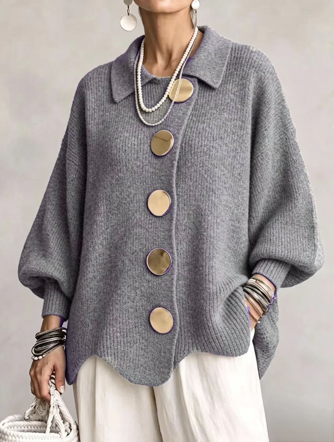 Gray cardigan with collar and gold-tone buttons worn over white pants