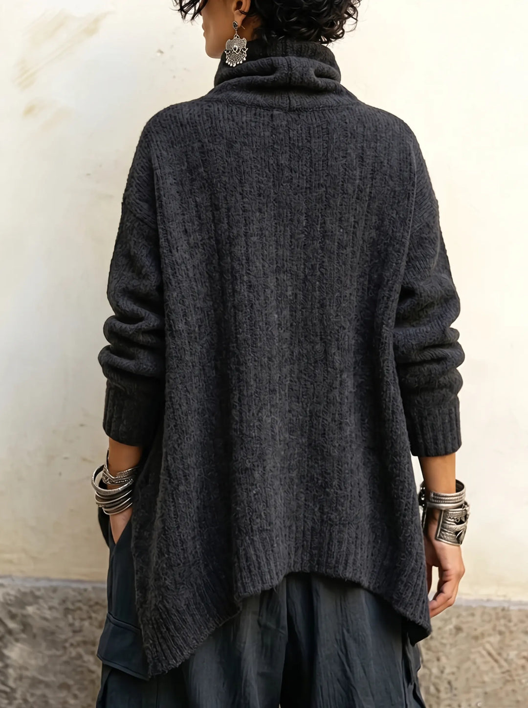 Back view of the charcoal knit with ribbed texture and longer pointed hem