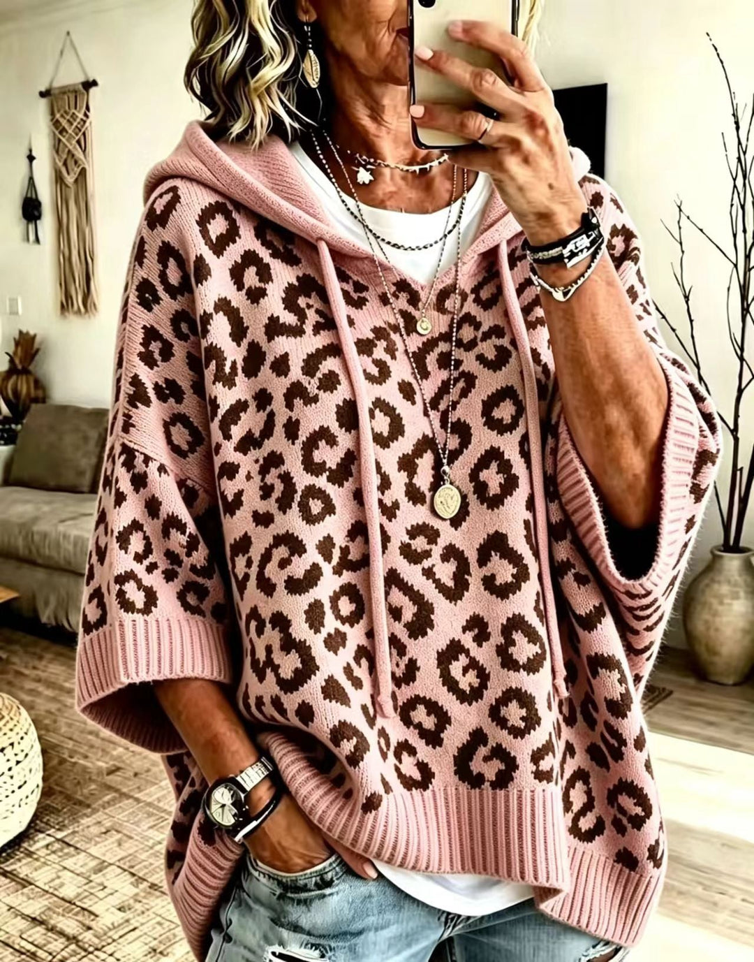 Dusty pink leopard print sweater with hood, worn loose over denim