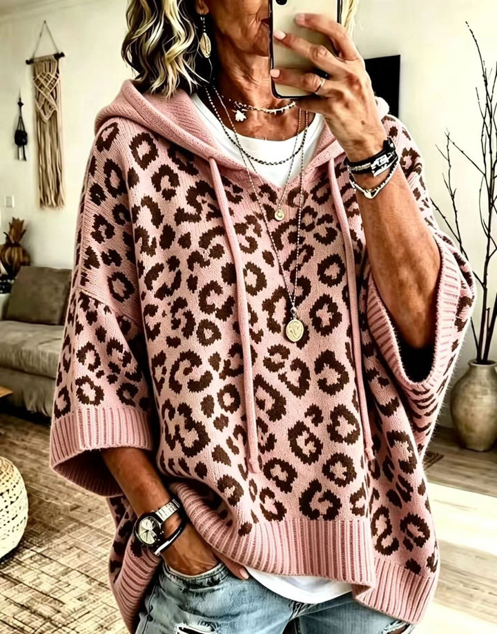 Dusty pink leopard print sweater with hood, worn loose over denim
