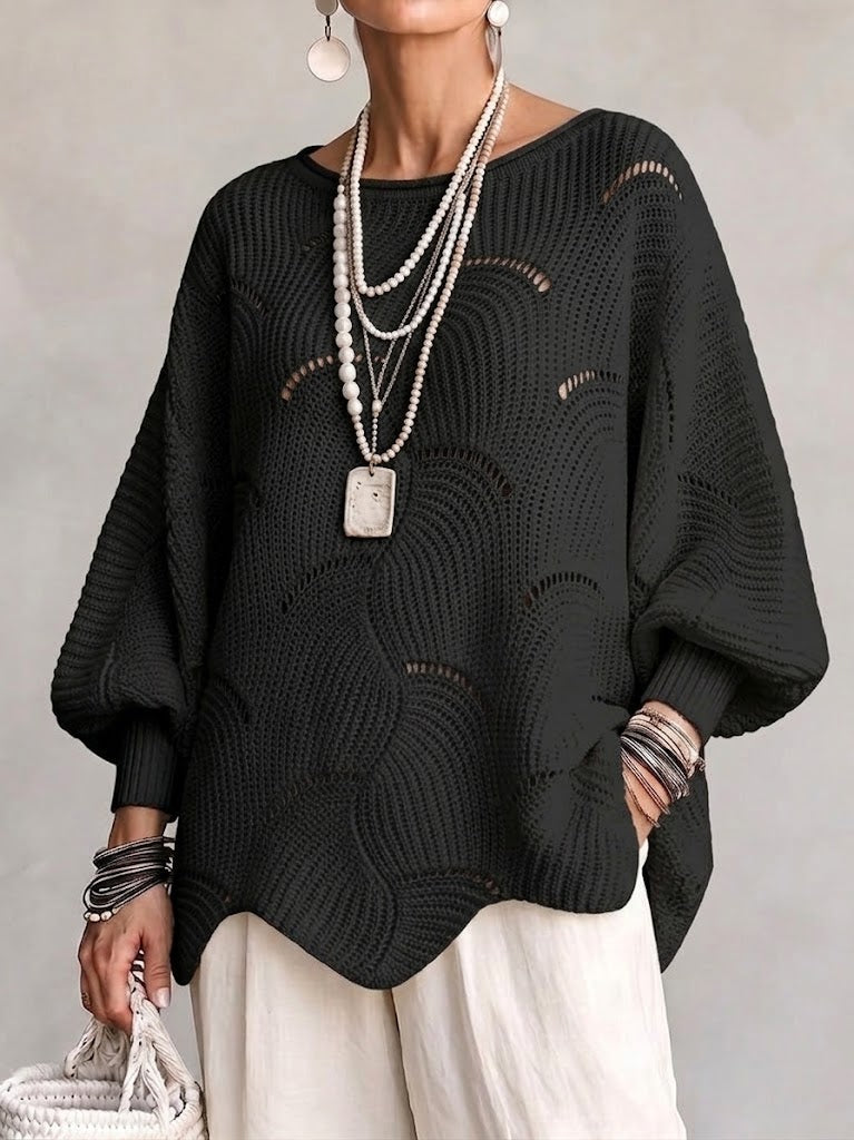 Black oversized openwork sweater over cream wide-leg pants