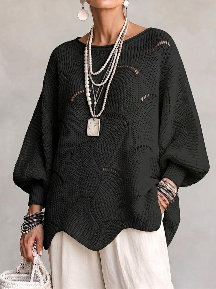 Black oversized openwork sweater over cream wide-leg pants
