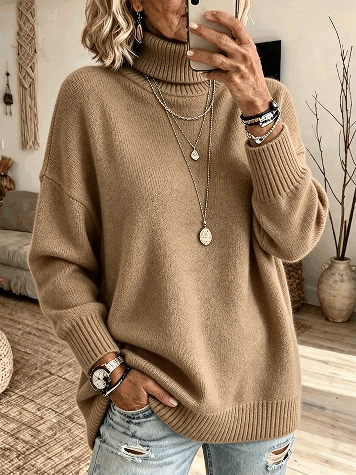 Camel turtleneck sweater with dropped shoulders, worn with ripped denim