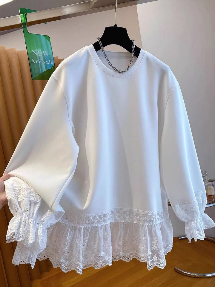 White sweatshirt on a hanger showing the wide sleeves and lace trim
