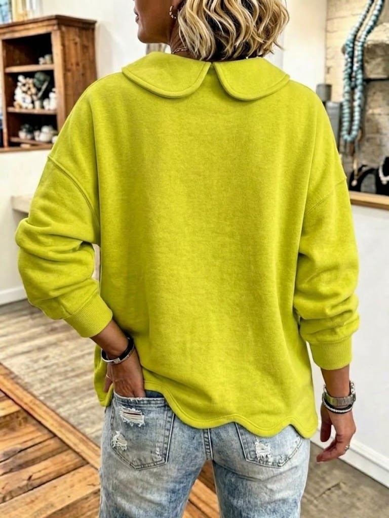 Back view of the lime sweatshirt showing the rounded collar and wavy hem