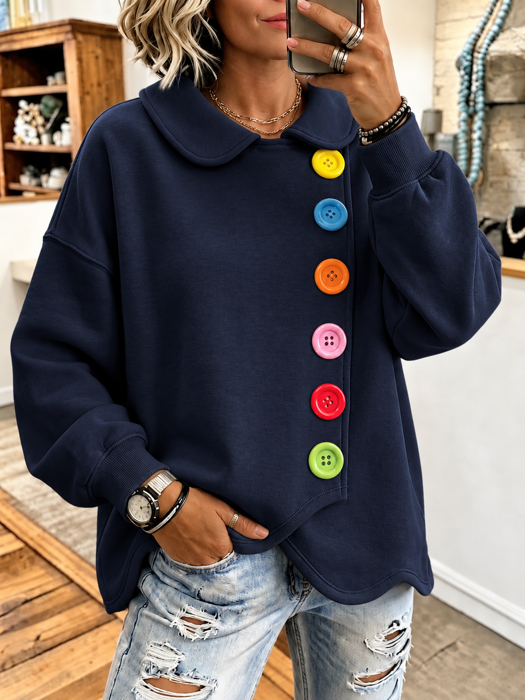 Navy sweatshirt with six bright buttons and a scalloped overlapping hem