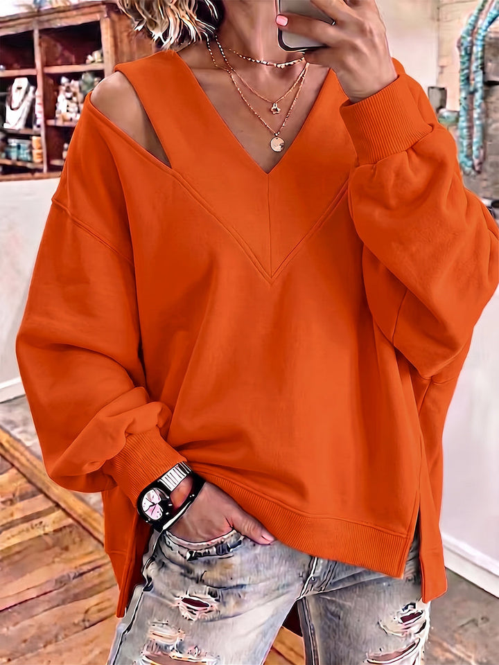 Orange sweatshirt with open shoulder cutout and side slits at the hem