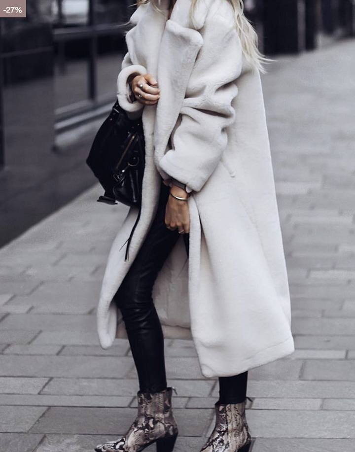 Ivory long plush coat with lapels styled with black pants and snakeskin ankle boots