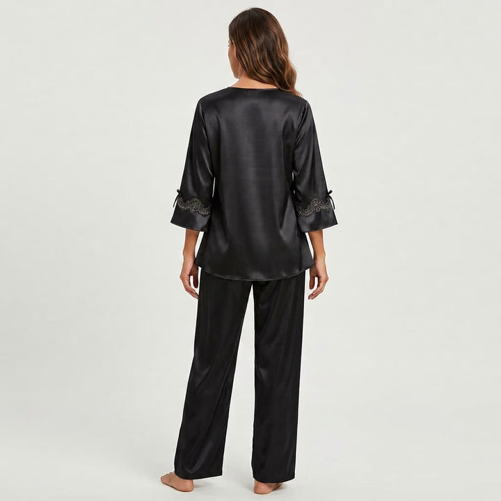 Back view of the black satin-look pajama set on a model