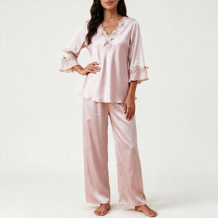 Woman wearing the light pink satin-look pajama set with lace trim, front view